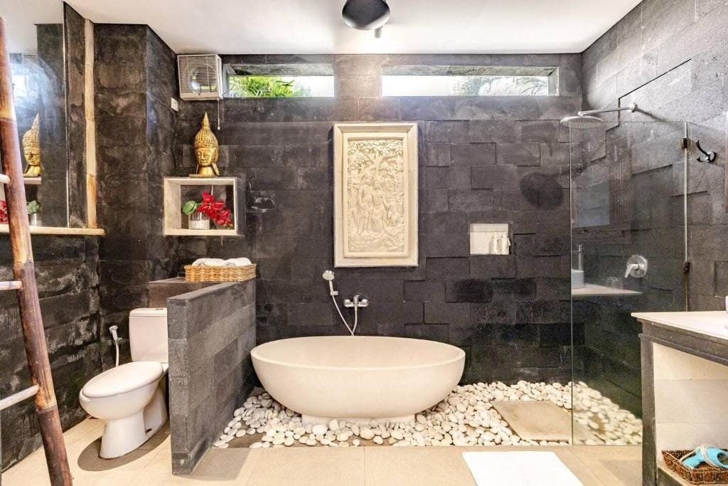 Bathroom 1: A cultural oasis with Balinese hand-carved window and mirror at Villa Carissa.