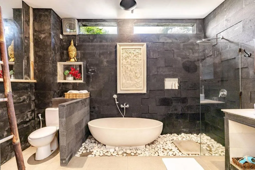 Bathroom 1: A cultural oasis with Balinese hand-carved window and mirror at Villa Carissa.