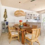 The villa features a bright open-plan dining area and a fully equipped kitchen. The wooden table and rattan chairs create a warm Balinese touch, perfect for family meals or friendly gatherings